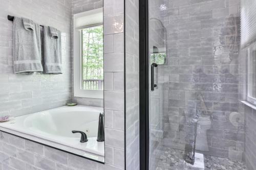 a white bathroom with a tub and a window at Adventures at Big Canoe - Spacious Cabin Rental in Big Canoe - Serene Nature Views, Cozy Fireplace, Spacious Decks, Walking Dist in Afton