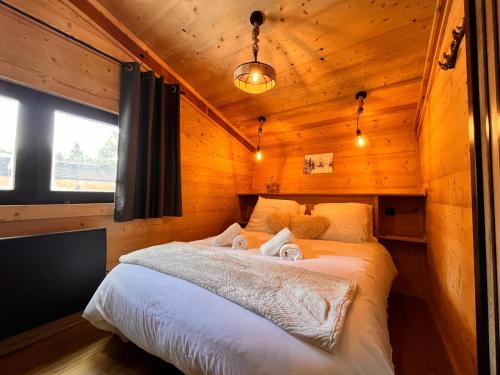 a bedroom with a bed in a wooden cabin at Chalet l'Epicéa dans la forêt, T3 avec terrasse & jardin à 5 min à pied des pistes P2000 in Bolquere Pyrenees 2000