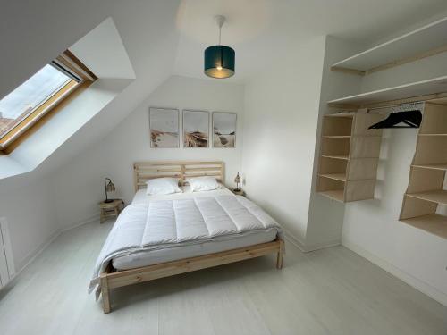 a bedroom with a bed in a white room at Ty Plom proche du centre et des plages in Plomeur