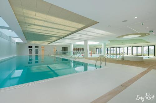 a large swimming pool in a large building at Prestige Pinea 613 - basen, sauna, jacuzzi w cenie pobytu - Easy - Rent Apartments in Pobierowo