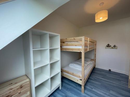 a room with a bunk bed and a staircase at Ty Plom proche du centre et des plages in Plomeur