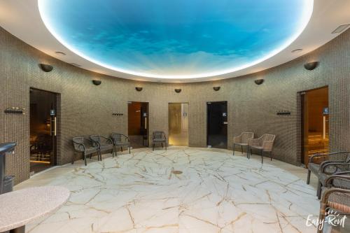 a large room with a large marble floor and chairs at Prestige Pinea 613 - basen, sauna, jacuzzi w cenie pobytu - Easy - Rent Apartments in Pobierowo
