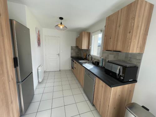 a kitchen with a sink and a microwave at Ty Plom proche du centre et des plages in Plomeur
