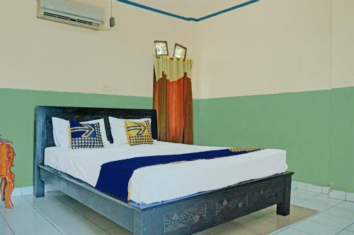 a bedroom with a bed with blue and green walls at Hotel O Romli in Rumpuktulunghoni