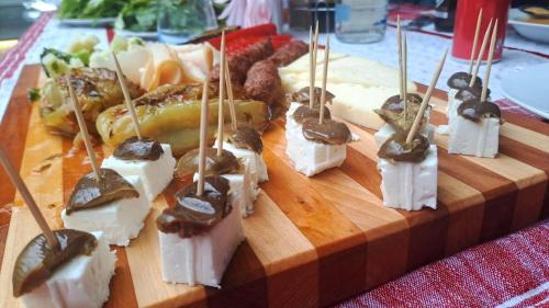 a bunch of food on a wooden board with tooth picks at Mon Ami Boutique Hotel in Shkodër