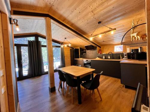 a kitchen and dining room with a table and chairs at Chalet l'Epicéa dans la forêt, T3 avec terrasse & jardin à 5 min à pied des pistes P2000 in Bolquere Pyrenees 2000