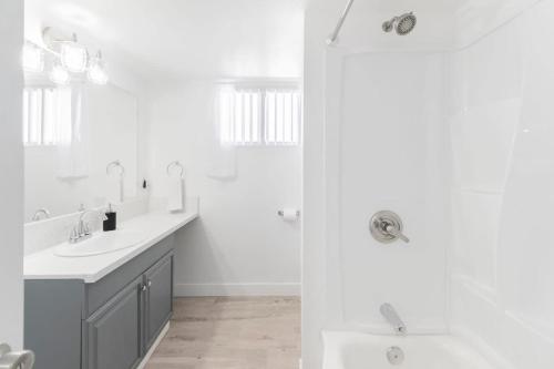 a white bathroom with two sinks and a shower at Chic 2-Bed Oasis Sleeps 6! Minutes From Strip! in Las Vegas