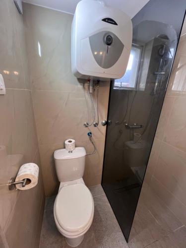 a bathroom with a toilet with a camera on the wall at Apartments and bungalows vila Dalibor in Nin