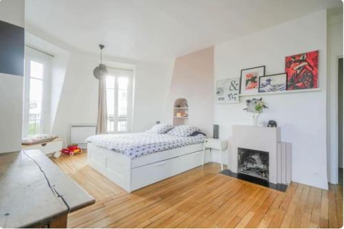 une chambre blanche avec un lit et une cheminée dans l'établissement Sweet home, à Paris