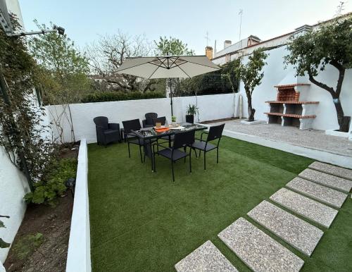 a patio with a table and chairs and an umbrella at Casa Santos in Sardoal