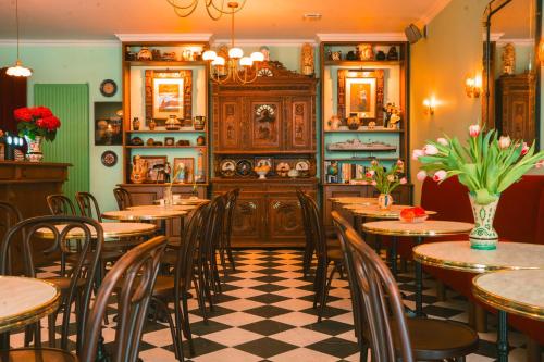 un restaurant avec des tables et des chaises en bois et un sol en damier dans l'établissement Hôtel Le Croiseur Ginette - Entièrement rénové, à Saint-Malo