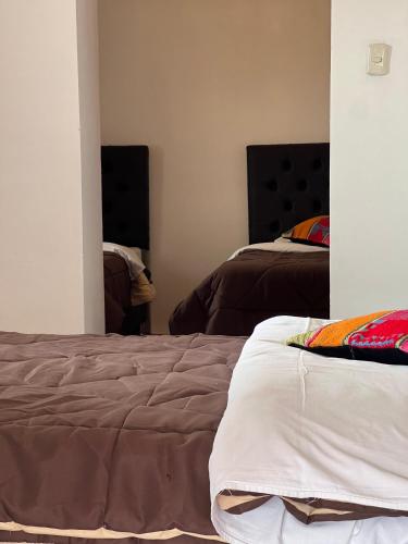 a bedroom with two beds in a room at Auquis Hostel in Cusco