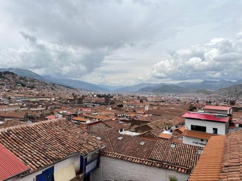 a view of a city with roofs and mountains at Auquis Hostel in Cusco