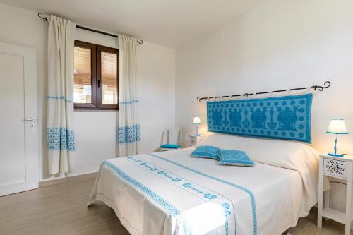 Un dormitorio con una cama grande con cabecero azul. en Casa Paola, en Tortolì