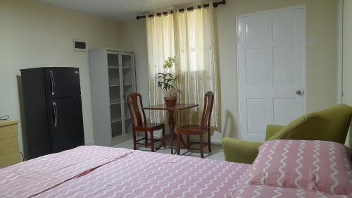 a bedroom with a bed and a table and chairs at Michael's place in Oranjestad