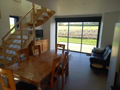 une salle à manger avec une table et un escalier dans l'établissement Maison Beniguet 6 places proche Paimpol et Tréguier, à Pleumeur-Gautier