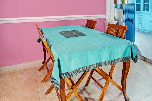 a table with two chairs and a green table cloth at Hotel O Amole Homestay Syariah in Cilacap