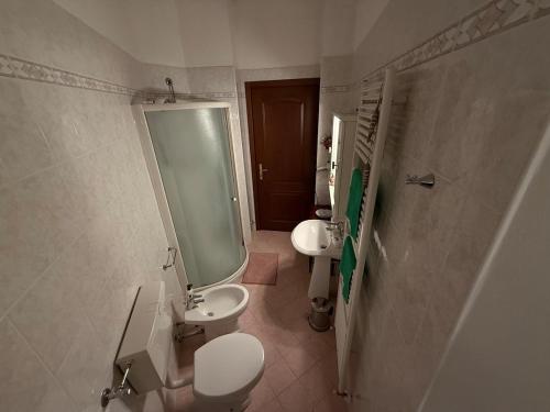 a bathroom with two sinks and a toilet and a mirror at Leila's House Fontane Del Duca in CastellʼArquato