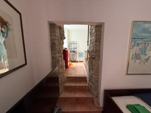 a hallway with a staircase with a stone wall at Leila's House Fontane Del Duca in CastellʼArquato