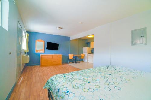 a bedroom with a bed and a blue wall at OYO Hotel Midland in Midland