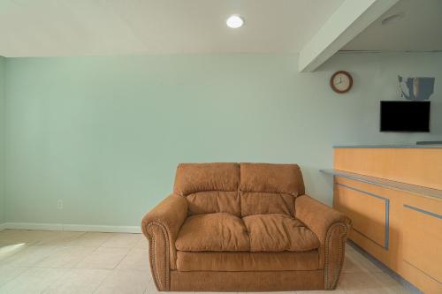 a brown chair in a room with a tv at OYO Hotel Midland in Midland
