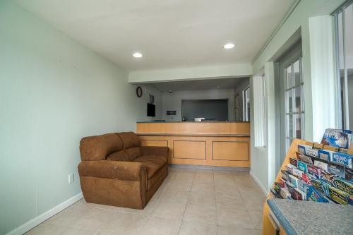 a living room with a couch and a kitchen at OYO Hotel Midland in Midland