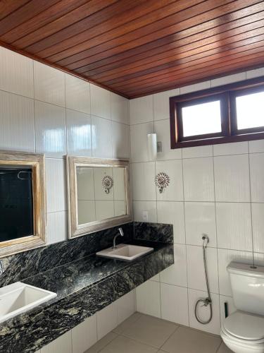 a bathroom with two sinks and a toilet at Aroeiraecocasa in Morro de São Paulo