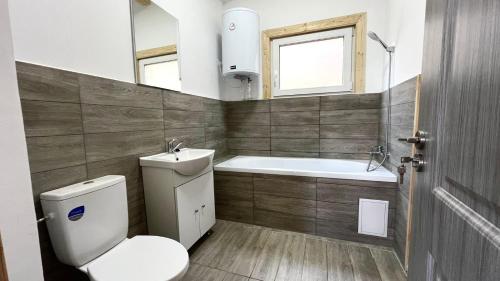 a bathroom with a toilet and a tub and a sink at Cricova House in Colibiţa