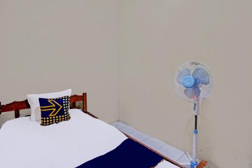 a bedroom with a fan next to a bed at Hotel O Nurul Homestay Syariah in Gresik