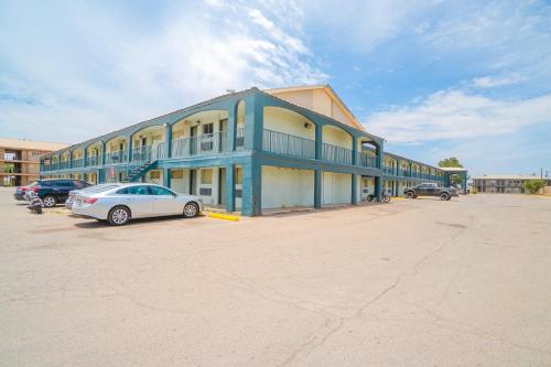 a blue building with a car parked in a parking lot at OYO Hotel Midland in Midland
