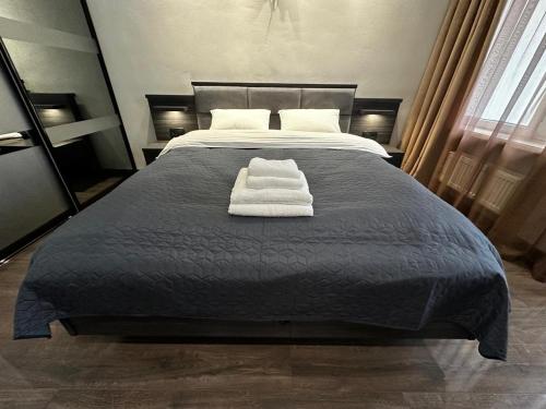 a bed with two white towels on top of it at Arcadia apartment & sea terrace in Odesa