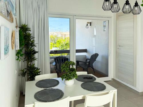 a dining room with a white table and chairs at Vistamare Oltremare in San Cataldo