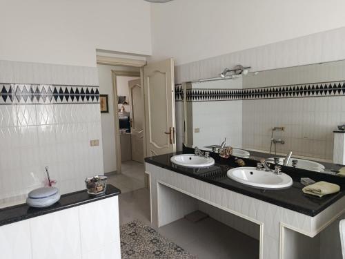 a bathroom with two sinks and a large mirror at Da Maurizio e Luisa in Castiadas
