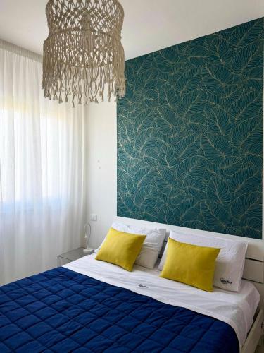 a bedroom with a blue bed with yellow pillows at Vistamare Oltremare in San Cataldo