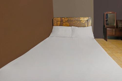 a large white bed in a room with at OYO 92308 Kos Duduk in Lajor