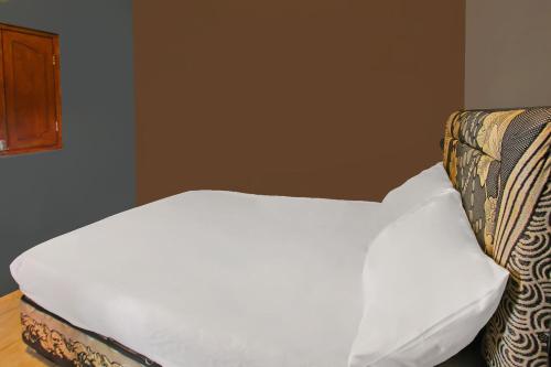 a white bed sitting in a room with at OYO 92308 Kos Duduk in Lajor