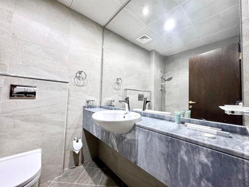 a bathroom with a sink and a toilet at Al Manara Classic Deluxe Studio in Dubai