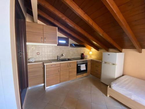 a kitchen with wooden cabinets and a white refrigerator at Cosy Nest Apartment in the Heart of Samos in Samos