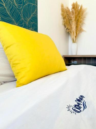 a white bed with a yellow pillow on it at Vistamare Oltremare in San Cataldo