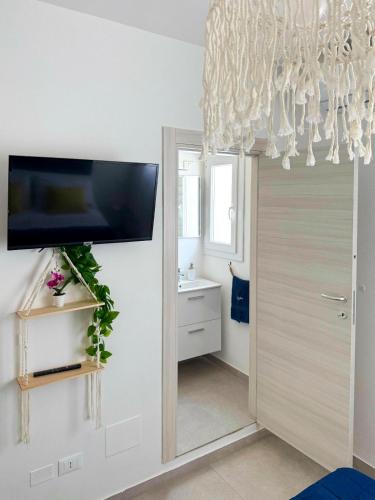 a bathroom with a sliding door with a tv on the wall at Vistamare Oltremare in San Cataldo