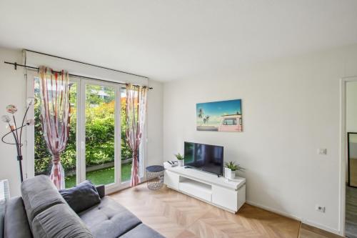 a living room with a couch and a tv at Grand F2 de 50m2 pour 4 personnes - Paris 10eme Gare du Nord, Stade de France in Saint-Denis
