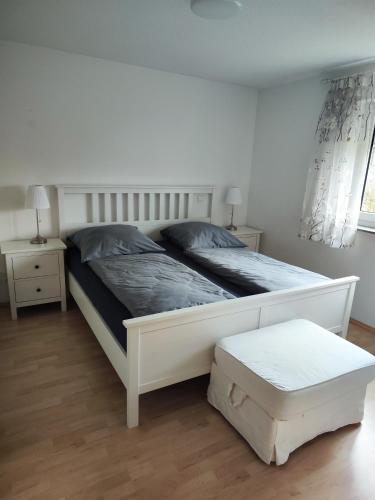 a bedroom with a white bed and two night stands at Gemütliche 2,5- Zimmer- Wohnung am Wasserturm in Rottweil in Rottweil