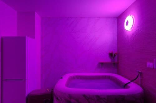 a purple bathroom with a tub in a room at Grand F2 de 50m2 pour 4 personnes - Paris 10eme Gare du Nord, Stade de France in Saint-Denis