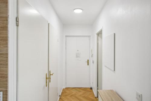 a hallway with white walls and a white door at Grand F2 de 50m2 pour 4 personnes - Paris 10eme Gare du Nord, Stade de France in Saint-Denis