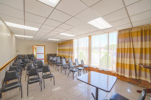 a conference room with chairs and tables andwindows at Masters Inn Selma Smithfield I-95 By OYO in Selma