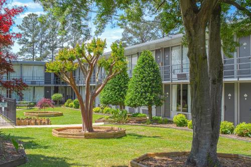 an apartment building with trees in front of it at Masters Inn Selma Smithfield I-95 By OYO in Selma