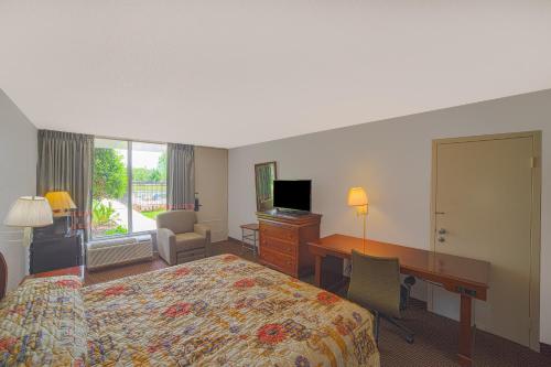 a hotel room with a bed and a desk and a desk at Masters Inn Selma Smithfield I-95 By OYO in Selma