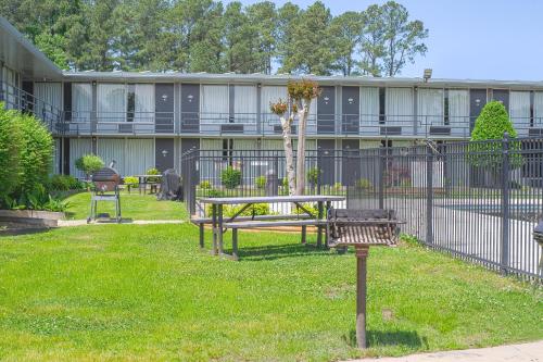 a park with a bench and a fence and a building at Masters Inn Selma Smithfield I-95 By OYO in Selma