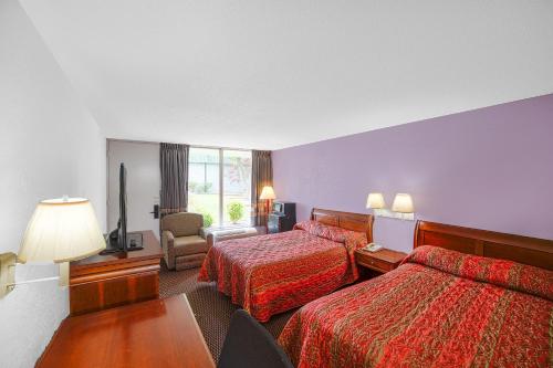 a hotel room with two beds and a television at Masters Inn Selma Smithfield I-95 By OYO in Selma