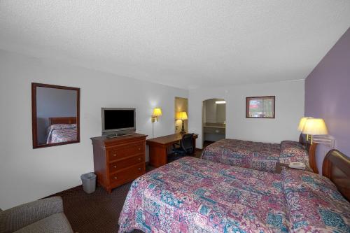 a hotel room with two beds and a television at Masters Inn Selma Smithfield I-95 By OYO in Selma